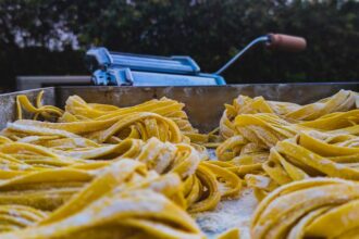 Frau formt mit der Unold Nudelmaschine Nora frischen Teig zu hausgemachter Pasta.