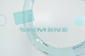 Zwei moderne, weiße Siemens Waschmaschine und Wärmepumpentrockner stehen nebeneinander in einem hellen, modernen Hauswirtschaftsraum, mit geöffneten Türen und leuchtendem Display, die ihre energiesparende Effizienz und hohe Verarbeitungsqualität betonen.