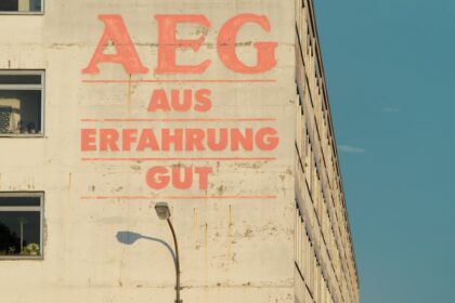 Weinglashalter in der Spülmaschine, der zwei Kristallgläser sicher an der Halterung fixiert, während Wasserstrahlen sie umspülen.